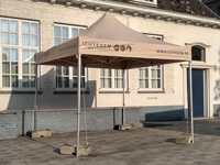 Tente pliante en PVC beige, ici avec impression sur les rives rectangulaires du toit